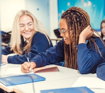 Children studying together in classroom smiling